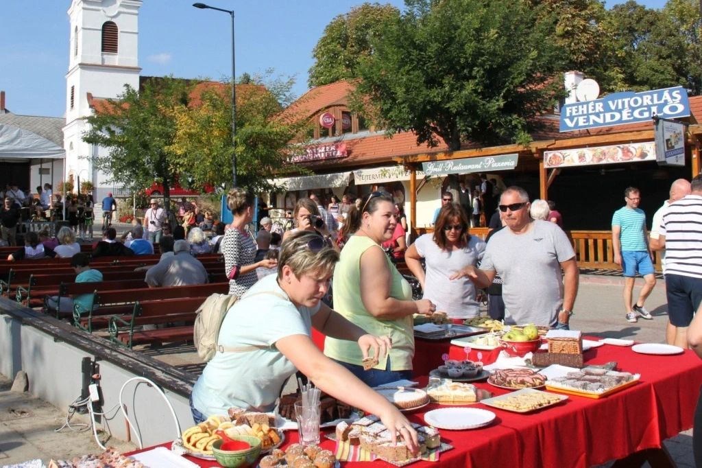 Pár sétál a balatoni mólón, napfényes időben