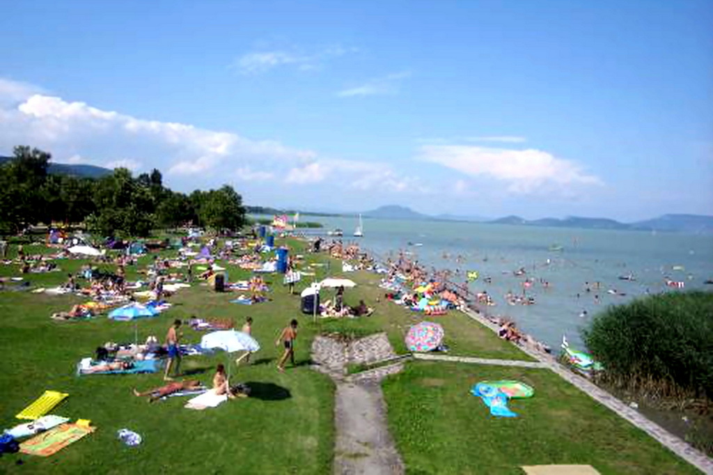 Pár sétál a balatoni mólón, napfényes időben